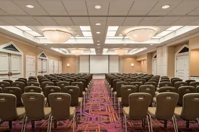 an empty room with rows of chairs and a projection screen at Crowne Plaza Englewood by IHG in Englewood