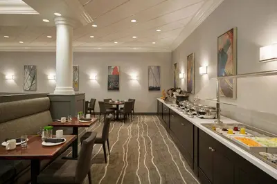 a restaurant with tables and chairs and a bar at Crowne Plaza Englewood by IHG in Englewood