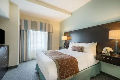 a hotel room with a large bed and a television at Staybridge Suites Wilmington - Brandywine Valley by IHG in Glen Mills