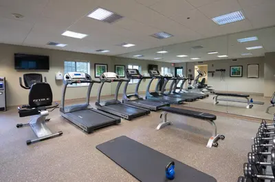 a gym with a row of treadmills and ellipticals at Staybridge Suites Wilmington - Brandywine Valley by IHG in Glen Mills