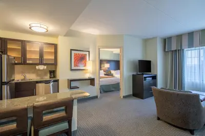 a hotel room with a kitchen and a bedroom at Staybridge Suites Wilmington - Brandywine Valley by IHG in Glen Mills