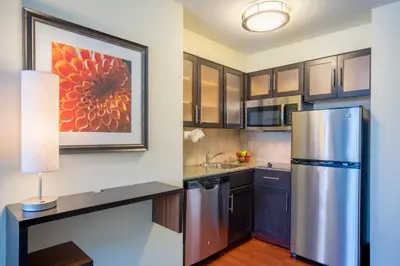a kitchen with a stainless steel refrigerator and a painting at Staybridge Suites Wilmington - Brandywine Valley by IHG in Glen Mills