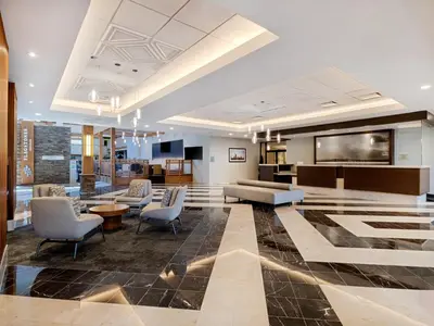 a lobby with couches and chairs in a building at Crowne Plaza Suffern-Mahwah by IHG in Suffern
