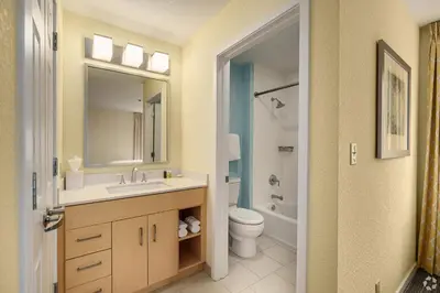 a bathroom with a sink and a toilet and a mirror at Avia Residences on Lincoln - Extended Stay in Malvern