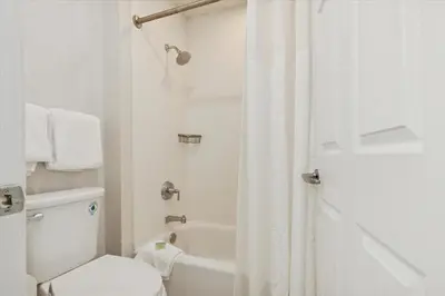 a white bathroom with a toilet and a shower at Avia Residences on Lincoln - Extended Stay in Malvern