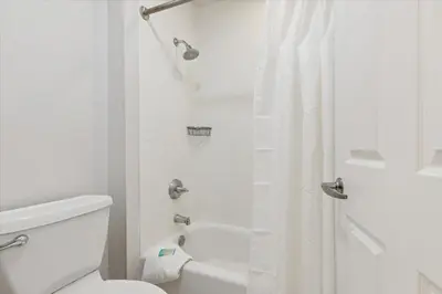 a white bathroom with a toilet and a shower at Avia Residences on Lincoln - Extended Stay in Malvern