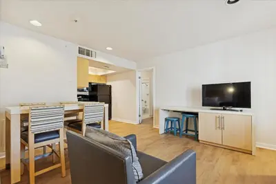 a living room with a dining room table and a television at Avia Residences on Lincoln - Extended Stay in Malvern