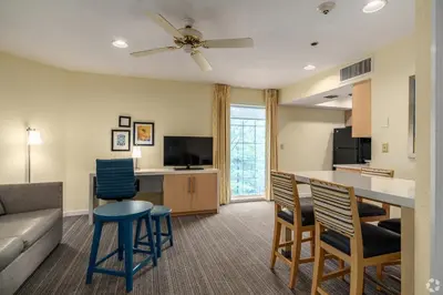 a living room with a couch and a table and chairs at Avia Residences on Lincoln - Extended Stay in Malvern