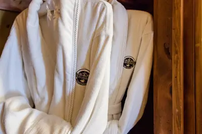 a white robe hanging on a wooden shelf at The Inn at Leola Village, a Historic Hotel of America in Lancaster