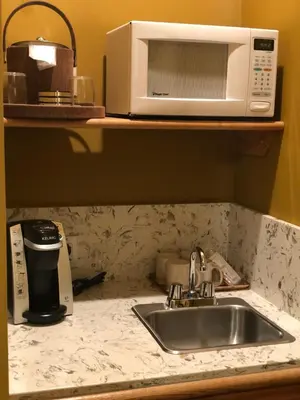 a kitchen counter with a sink and a microwave at The Inn at Leola Village, a Historic Hotel of America in Lancaster