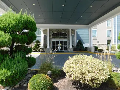 a front yard of a building with trees and bushes at Comfort Inn & Suites Glen Mills - West Chester in Glen Mills