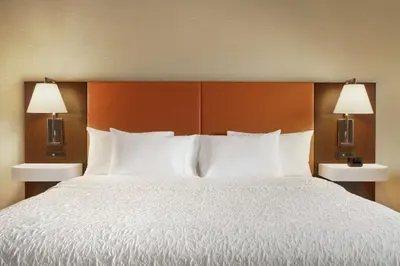 a bedroom with a bed with white pillows and two lamps at Hampton Inn & Suites Ephrata - Mountain Springs in Ephrata