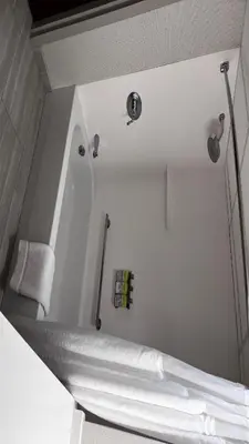 a white room with a bed and a mirror at Holiday Inn Express & Suites Williamsport by IHG in Williamsport