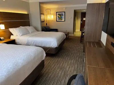 a hotel room with two beds and a chair at Holiday Inn Express & Suites Williamsport by IHG in Williamsport