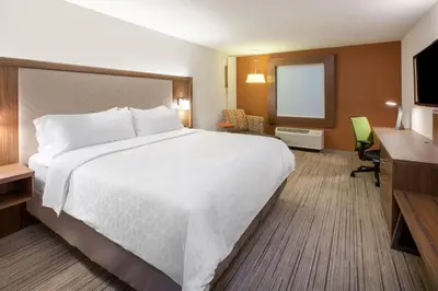 a hotel room with a large bed and a desk at Holiday Inn Express & Suites Williamsport by IHG in Williamsport