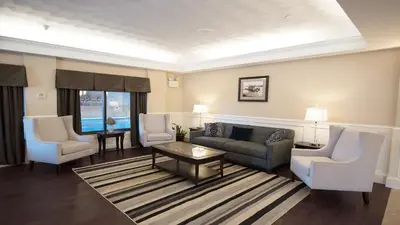 a living room with a couch and two chairs at Holiday Inn Williamsport by IHG in Williamsport