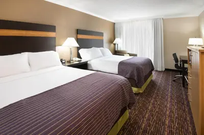 a hotel room with two beds and a desk at Holiday Inn Williamsport by IHG in Williamsport
