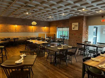 a dining room with wooden tables and chairs at Holiday Inn Williamsport by IHG in Williamsport