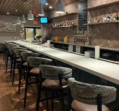a bar with a row of bar stools at Holiday Inn Williamsport by IHG in Williamsport