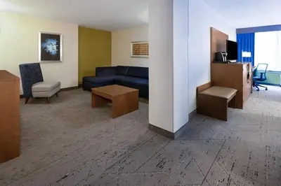 a living room with a blue couch and a table at Holiday Inn Express & Suites Ft. Washington - Philadelphia by IHG in Fort Washington