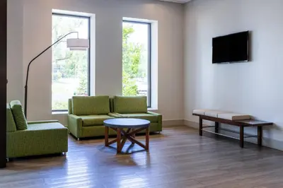 a living room with two chairs and a table and a tv at Holiday Inn Express & Suites Ft. Washington - Philadelphia by IHG in Fort Washington