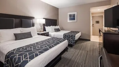 a hotel room with two beds and a flat screen tv at Best Western Plus Wilkes Barre-Scranton Airport Hotel in Pittston