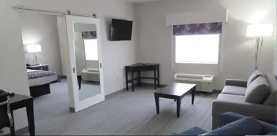 a living room with a couch and a mirror at Best Western Plus Wilkes Barre-Scranton Airport Hotel in Pittston