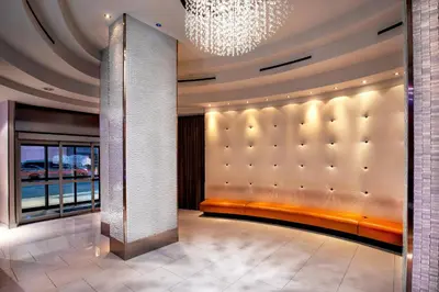 a living room with a large padded wall and a chandelier at Fairfield By Marriott New York Manhattan Times Square in New York