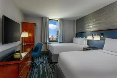a hotel room with two beds and a flat screen tv at Fairfield By Marriott New York Manhattan Times Square in New York