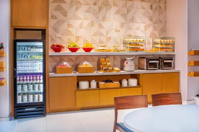 a kitchen with a refrigerator and a table with chairs at Fairfield By Marriott New York Manhattan Times Square in New York