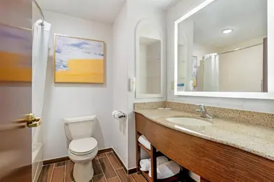a bathroom with a sink and a toilet and a mirror at Comfort Suites East Brunswick - South River in East Brunswick
