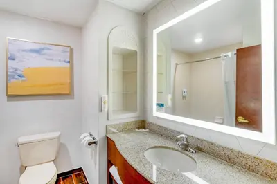 a bathroom with a sink and a toilet and a mirror at Comfort Suites East Brunswick - South River in East Brunswick