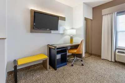 a room with a desk and a tv and a chair at Comfort Suites East Brunswick - South River in East Brunswick