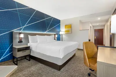 a hotel room with a large bed and a desk at Comfort Suites East Brunswick - South River in East Brunswick