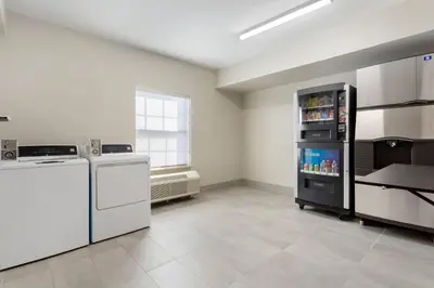 a kitchen with a refrigerator and a dishwasher at Comfort Suites East Brunswick - South River in East Brunswick