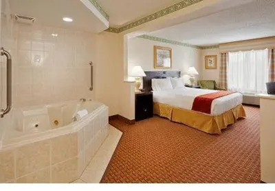 a hotel room with a bed and a bath tub at Holiday Inn Express Hotel & Suites Easton by IHG in Easton
