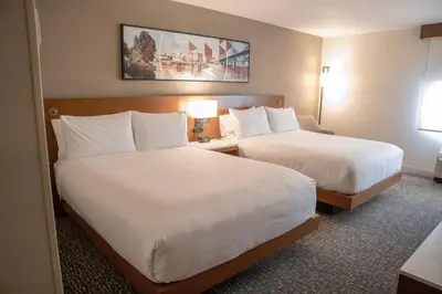 a hotel room with two beds with white sheets at Delta Hotels by Marriott Allentown Lehigh Valley in Fogelsville