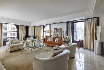 a living room with couches and chairs and a table at The Peninsula New York in New York