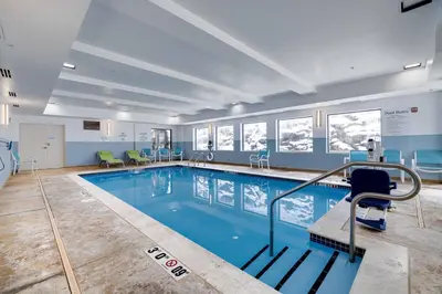 a large swimming pool with chairs in a building at Holiday Inn Express Wilkes Barre East by IHG in Wilkes-Barre