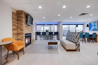 a living room with a fireplace and a couch and chairs at Holiday Inn Express Wilkes Barre East by IHG in Wilkes-Barre