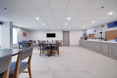 a dining room with tables and chairs and a tv at Holiday Inn Express Wilkes Barre East by IHG in Wilkes-Barre