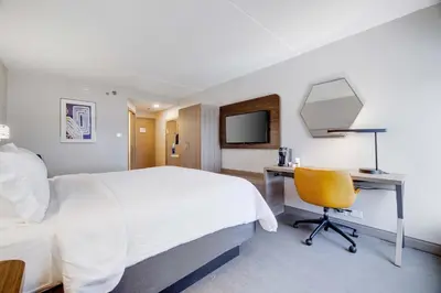 a hotel room with a bed and a desk and a mirror at Holiday Inn Express Wilkes Barre East by IHG in Wilkes-Barre
