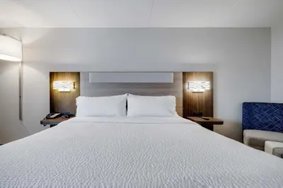 a bedroom with a white bed and a blue chair at Holiday Inn Express Wilkes Barre East by IHG in Wilkes-Barre