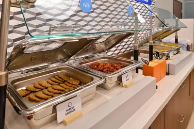 a buffet line with trays of food on a counter at Holiday Inn Express & Suites White Haven - Poconos by IHG in White Haven