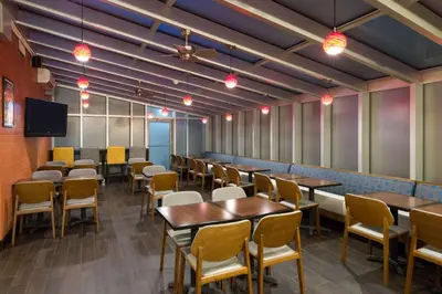 a dining room with tables and chairs and a tv at Hampton Inn Manhattan - Times Square South in New York
