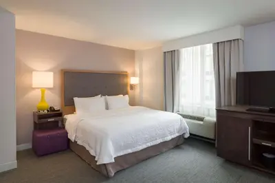 a hotel room with a bed and a flat screen tv at Hampton Inn Manhattan - Times Square South in New York