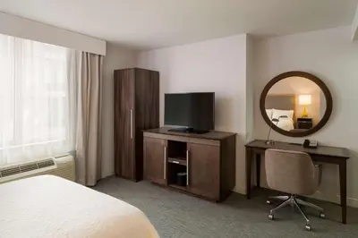 a hotel room with a bed and a tv and a mirror at Hampton Inn Manhattan - Times Square South in New York