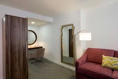 a living room with a red couch and a mirror at Hampton Inn Manhattan - Times Square South in New York