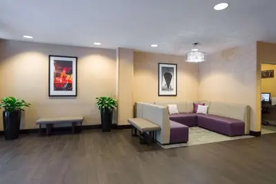 a waiting room with a couch and chairs in a lobby at Hampton Inn Manhattan - Times Square South in New York