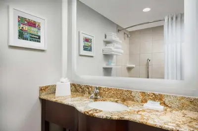 a bathroom with a sink and a large mirror at Hampton Inn Manhattan-35th St Empire State Bldg in New York